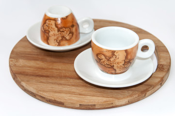 Pair of beautiful coffee mugs on the wooden board