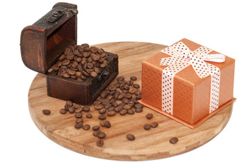 Wooden chest with spilled coffee beans on the wooden board