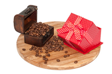 Wooden chest with spilled coffee beans on the wooden board