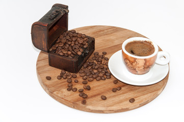 Cup of coffee with wooden chests on the wooden board