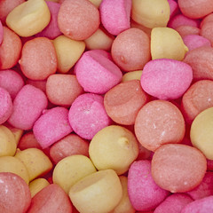 Fototapeta na wymiar pale pink and yellow candies, sweet background