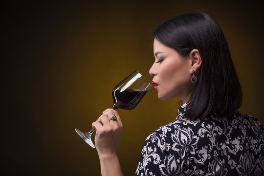 Asian woman drinking red wine