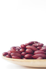 Red beans on wooden spoon isolated on white background
