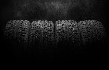 Tires with water drops over black background