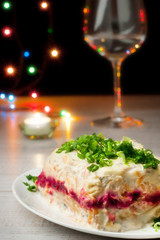 Herring salad with glass of champagne and light