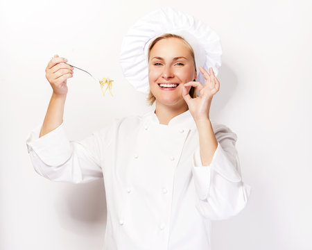 Woman chef showing a sign perfect, with pasta noodle on fork, ov