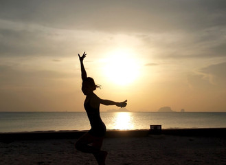 Fototapeta premium silhouette of a girl on the beach with sunset