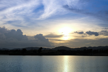 Sunset behind the lake and hill at nightfall