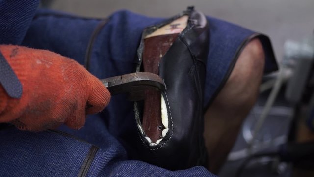 Production designer shoes. Footwear production by human hands. screed boot soles