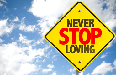 Never Stop Loving sign with sky background