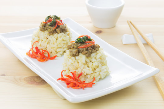 Rice Topped with Stir-Fried Pork and Basil and Chopsticks and Small Cup