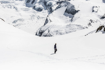Fototapeta na wymiar Man walking on the snow with the background of snow mountain.