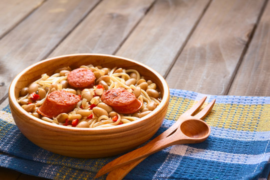 Traditional Chilean dish Porotos con Riendas, made of cooked beans, linguine, fried sausage, photographed with natural light (Selective Focus, Focus one third into dish)
