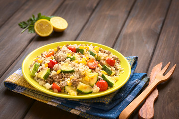 Rice dish with mincemeat and vegetables (sweet corn, cherry tomato, zucchini, onion), photographed with natural light (Selective Focus, Focus in the middle of the dish)