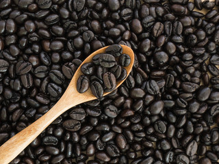Obraz premium Coffee Beans 4 - Top view of black coffee beans in wood spoon on wood background