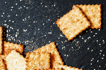 Sweet crackers, sesame, sugar grains on a dark background, top v