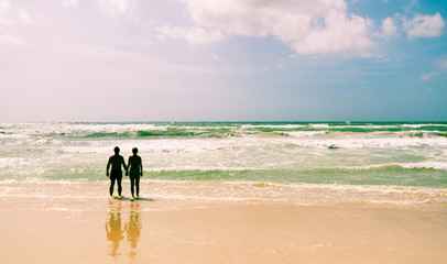 Junges Pärchen am Strand, Händchen haltend