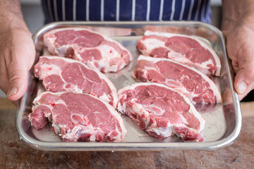 Butcher holding a Tray of lamb steaks