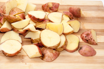 Sliced raw young potatoes on the wooden board