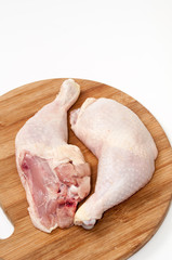 Chicken drumsticks on the wooden board ready for cooking