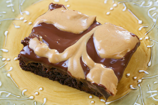 Chocolate sheet cake brownies with milk chocolate and peanut butter swirled topping with plate