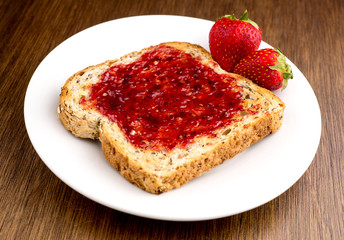 Strawberry jam spread on multi-grain toast