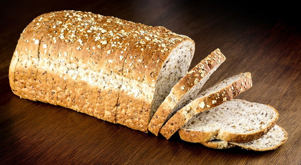 Fresh whole wheat bread against wooden background