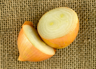 Aerial of onion halves on rustic hessian background