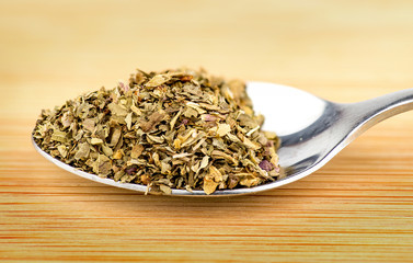 Macro of spoonful of dried oregano herb