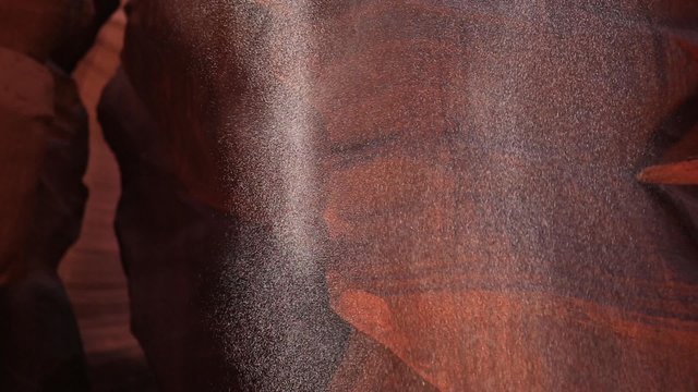 Sand Falling in Ray of Light in Antelope Canyon