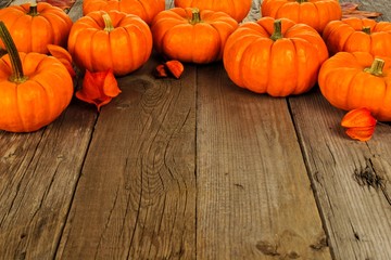 Top border arrangement of autumn pumpkins against an old wood background