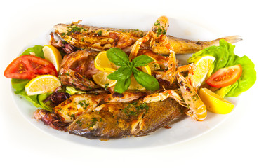 Grilled fish with vegetables on plate. Isolated on a white