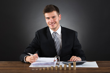 Businessman Doing Accounting At Desk