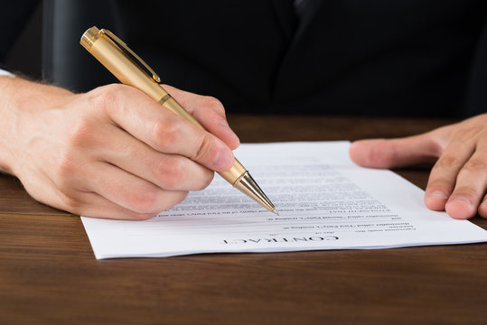 Businessperson Hands With Pen Over Contract Paper