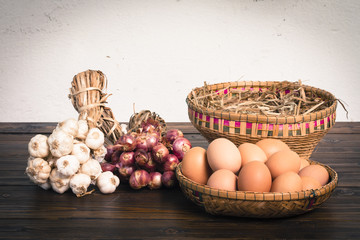 Herb ingredients,  onion, garlic and eggs on dark wood table