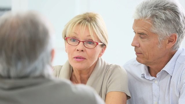 Portrait of senior couple talking to advisor