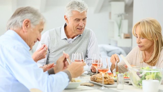 Group of senior people having lunch together at home