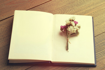 Dried flowers and book on wooden background