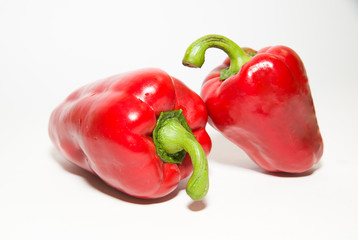 Two ripe red peppers on over white