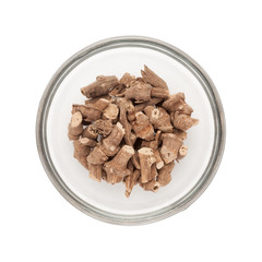 Top view of Organic Ganthoda or Long pepper Roots (Piper longum) half filled in glass bowl isolated on white background.