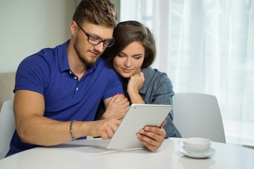 Cheerful couple with tablet pc at home
