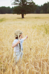 Naklejka na ściany i meble boy walking on a field of rye 