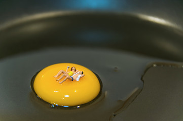 Miniature people sleeping on egg.