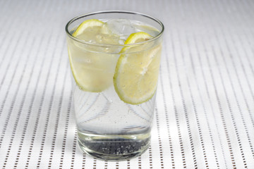 Glass of gin and tonic with several lemon slices