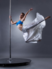 Pretty female dancer turning around pylon
