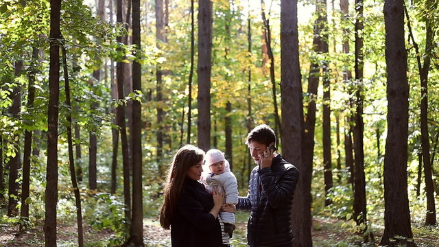 Family walk in the nature in autumn.Weekend outdoors in the woods.