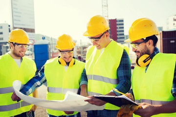 group of builders with tablet pc and blueprint