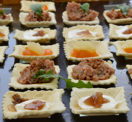 Salatini su piatto nero, antipasto
