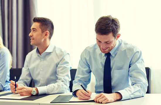 group of smiling businesspeople meeting in office