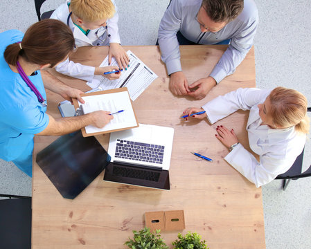 Male and female doctors working on reports in medical office